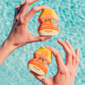 Mango Peach Flav bottles held poolside