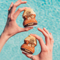 Coconut Cream Flav bottles held poolside