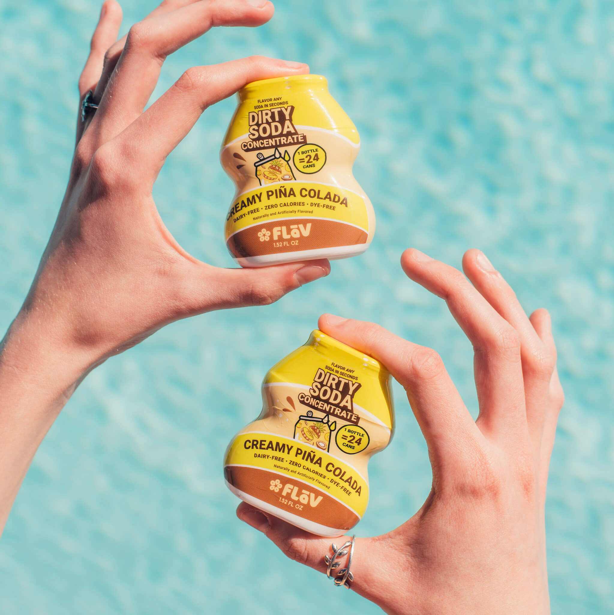 Creamy Pina Colada Flav bottles held poolside