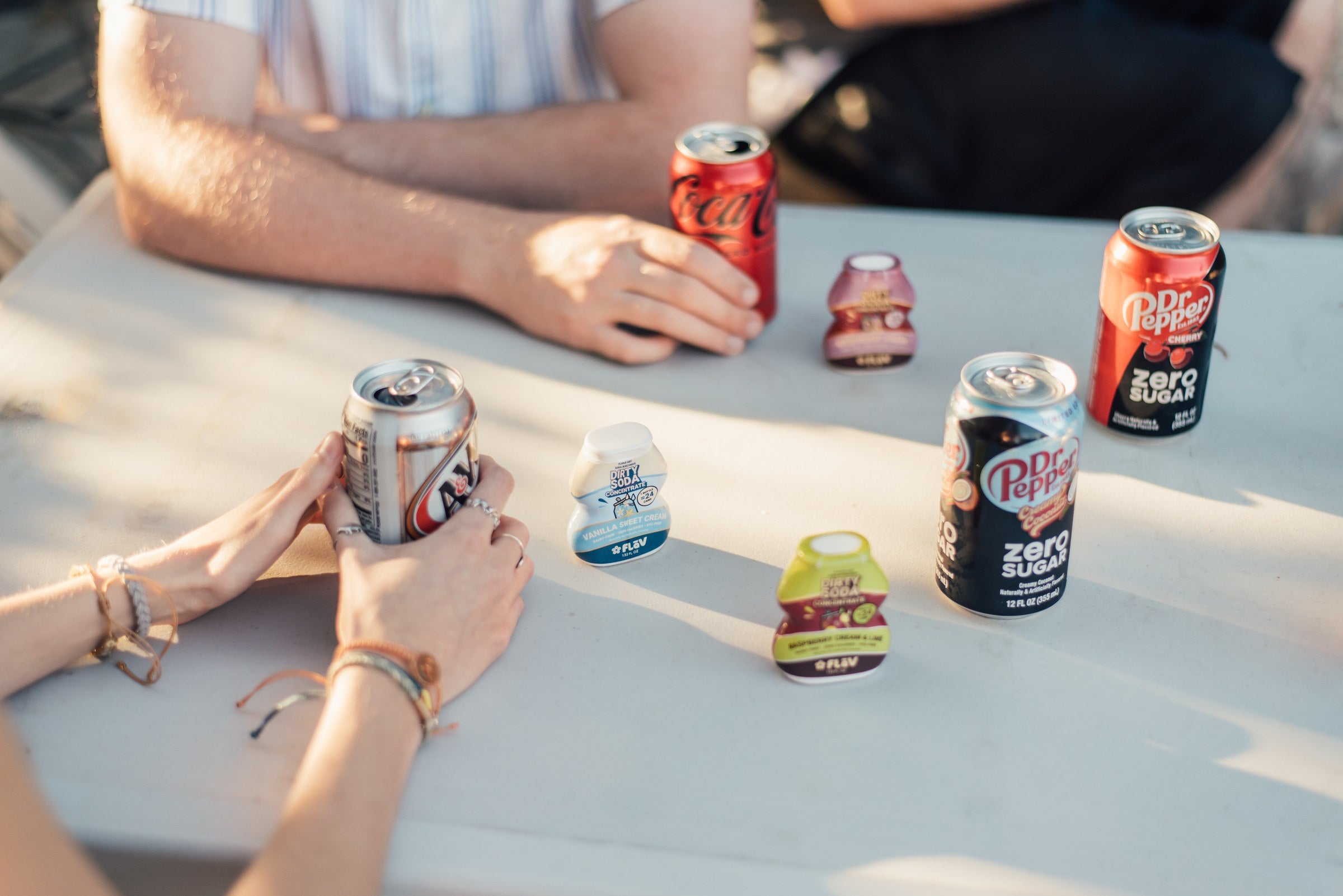 Vanilla Sweet Cream Flav bottle with assorted dirty sodas on an outdoor patio table